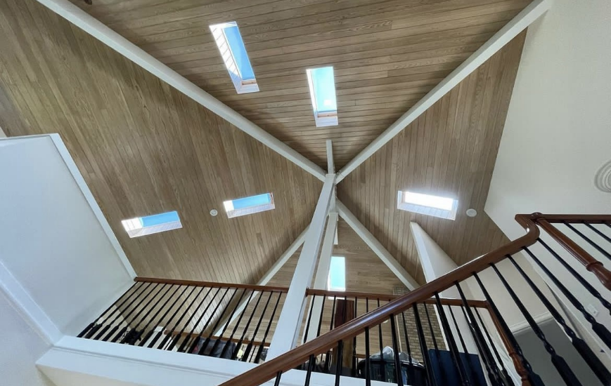 Photo of a wood paneled ceiling with tinted skylights